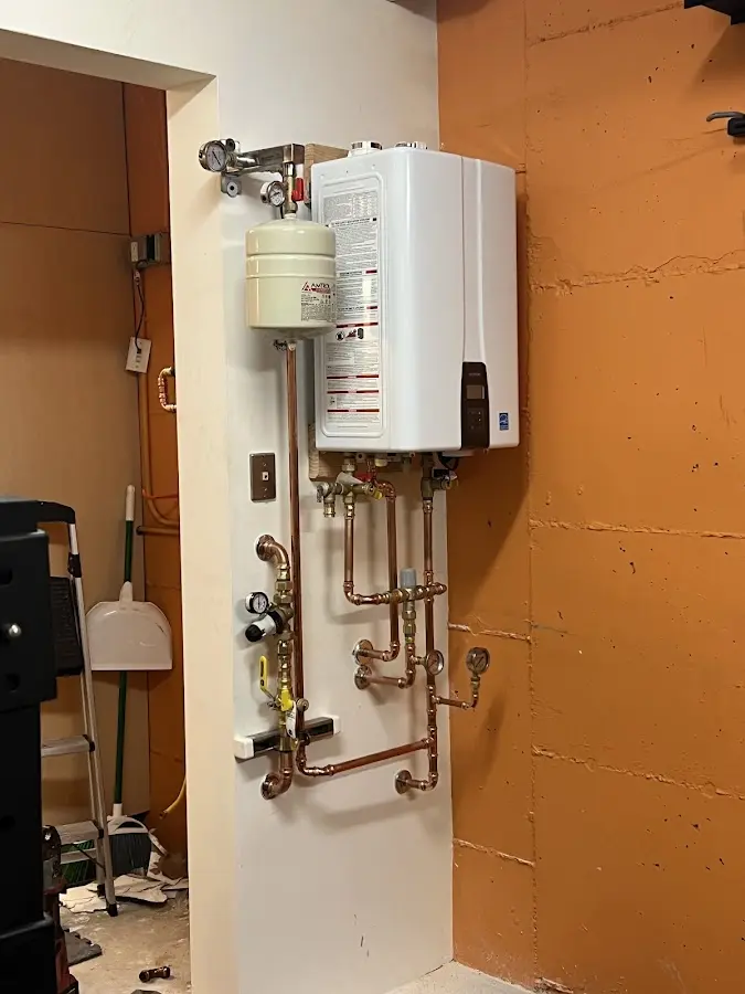 Plumbing technician inspecting water heater connections in Cross Plains